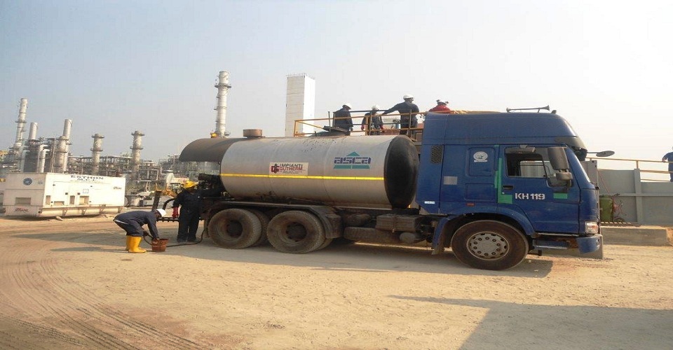 Industrial tanker truck and project personnel at an oil and gas site